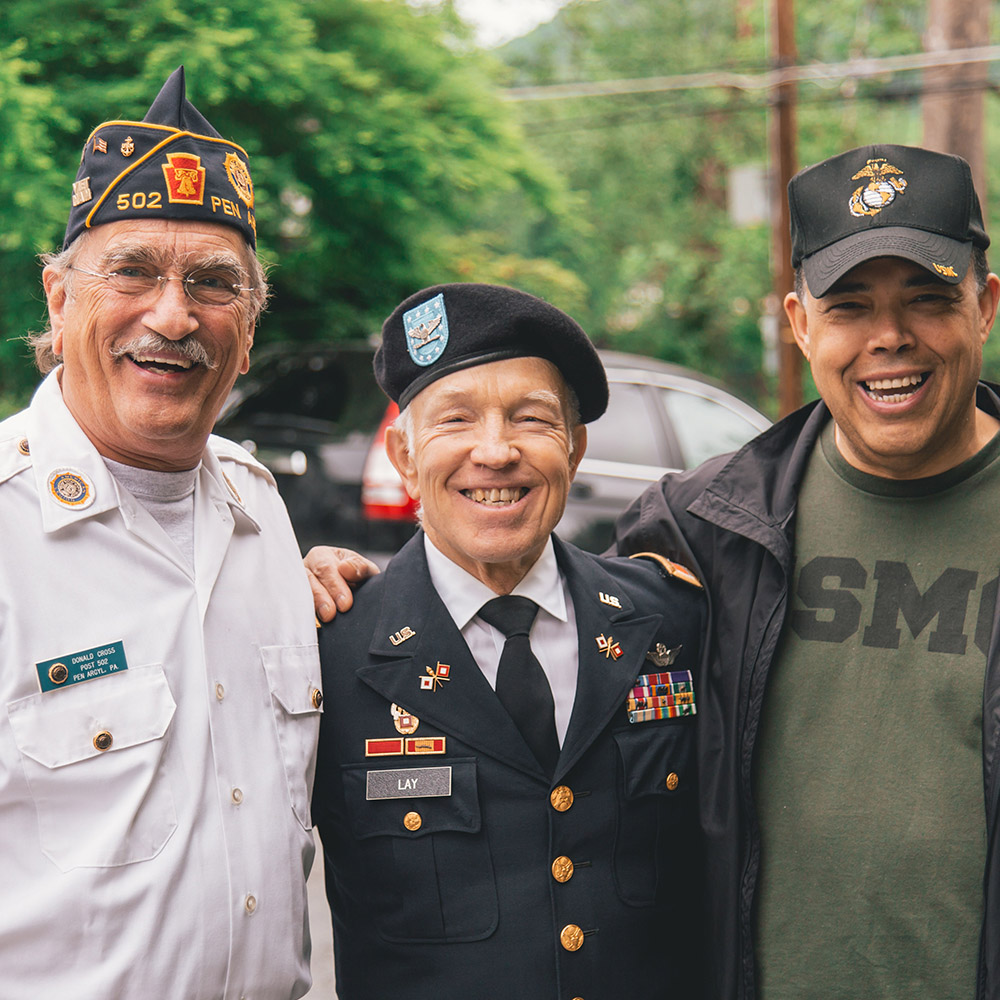 Three veterans standing together and smiling