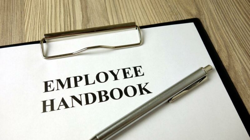 Employee handbook with pen on desk