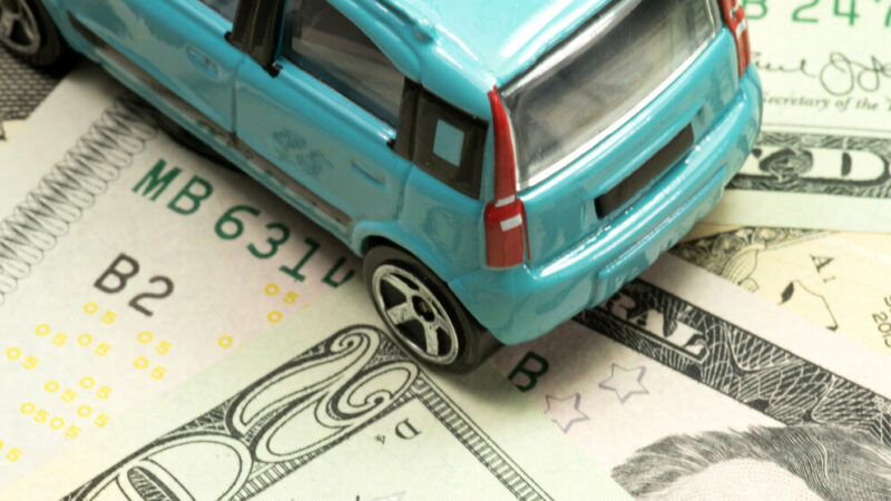A small car and dollar banknotes