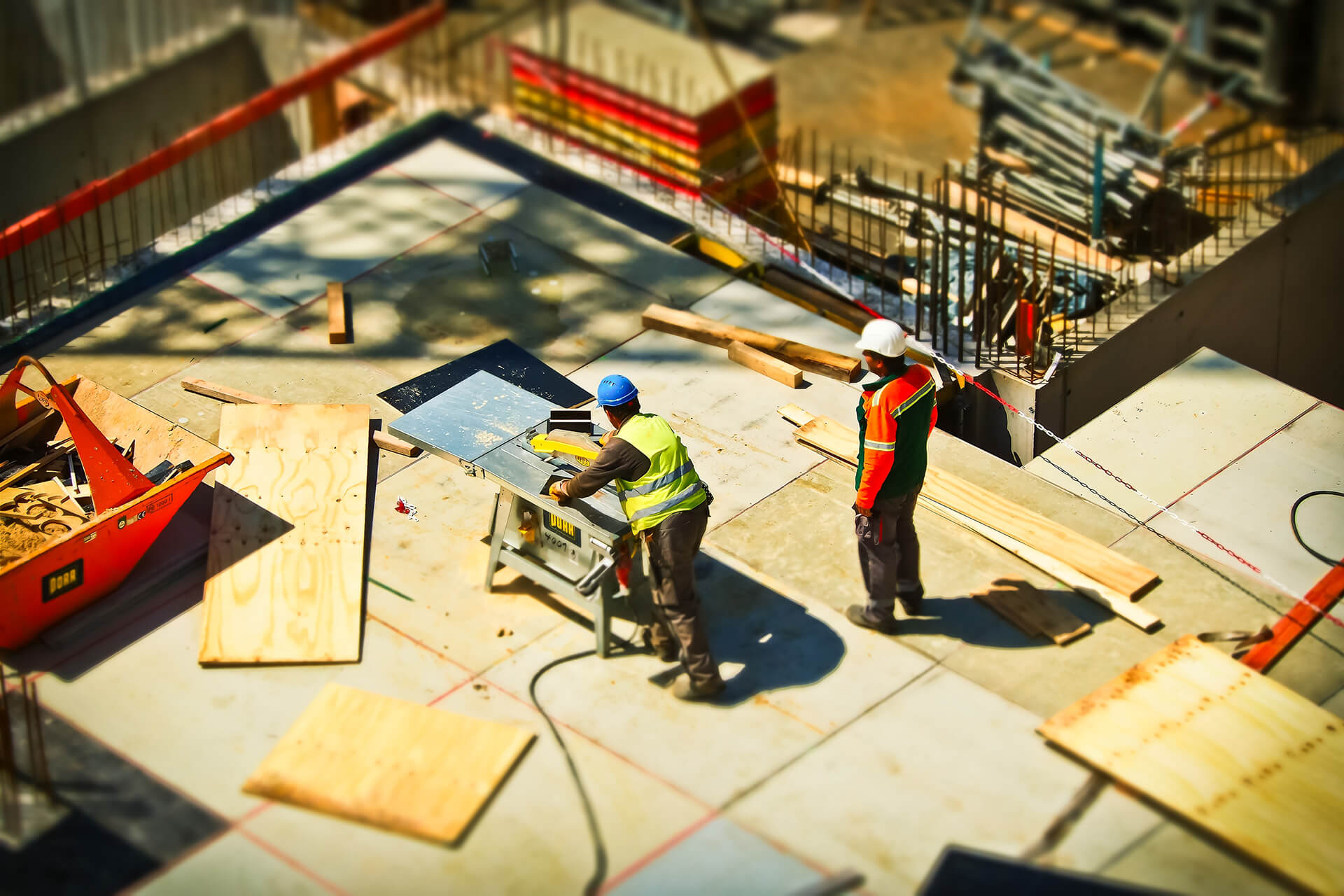 Two Men Cutting Wood On A Table Saw At A Construction Site