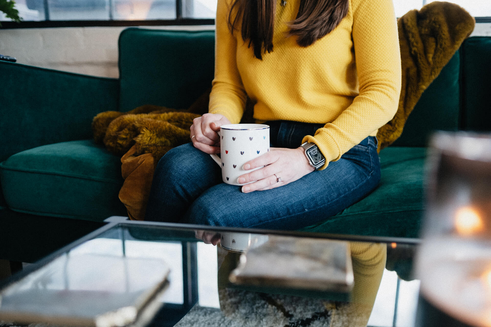 Woman Holding Coffee Mug On Green Couch